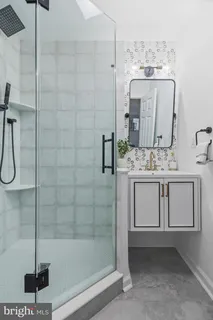 a bathroom with a shower sink and mirror