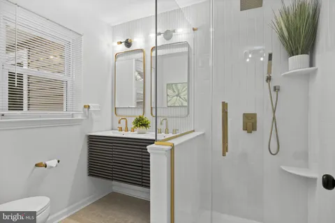 a bathroom with a sink a toilet and shower