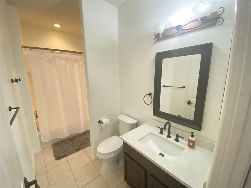 8763 Coco Plum Place Orlando, FL 32827 - Photo 15 of 26 a bathroom with a sink a toilet and shower a mirror