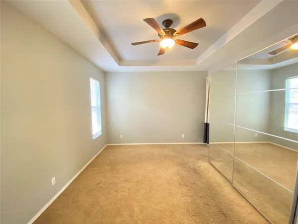 an empty room with closet and a chandelier fan