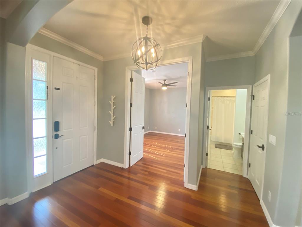 8763 Coco Plum Place Orlando, FL 32827 - Photo 2 of 26 a view of a hallway with wooden floor and staircase