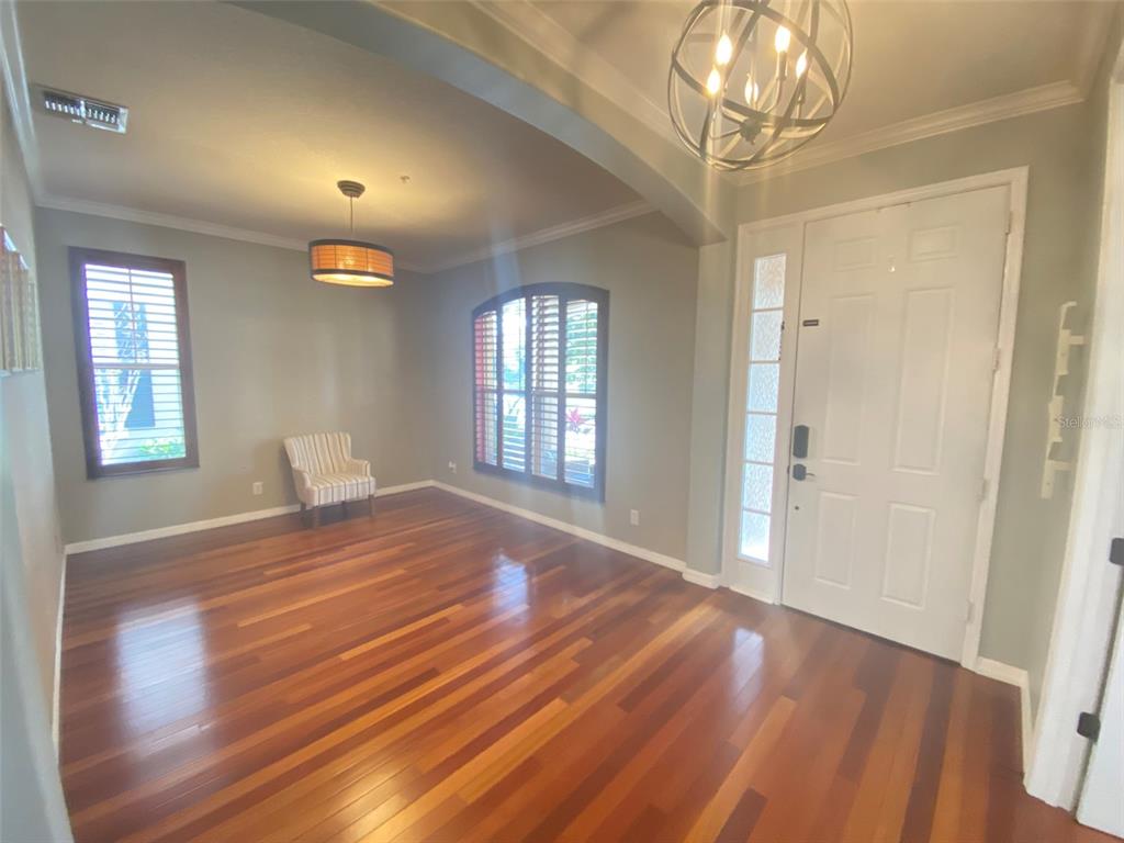 8763 Coco Plum Place Orlando, FL 32827 - Photo 3 of 26 a view of empty room with wooden floor and fan