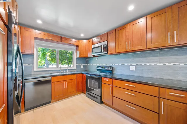 a kitchen with stainless steel appliances granite countertop a sink and cabinets
