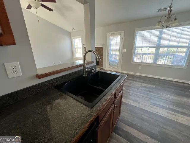 a kitchen with granite countertop a stove a sink and a window
