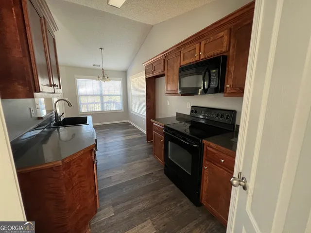 a kitchen with granite countertop a stove and a sink