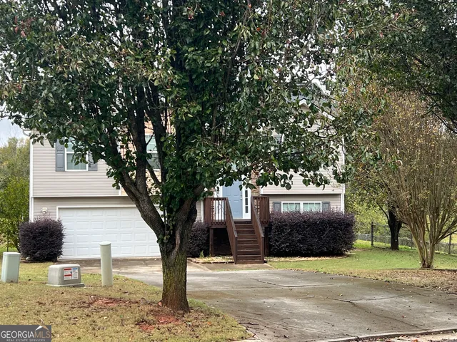 a front view of a house with a tree