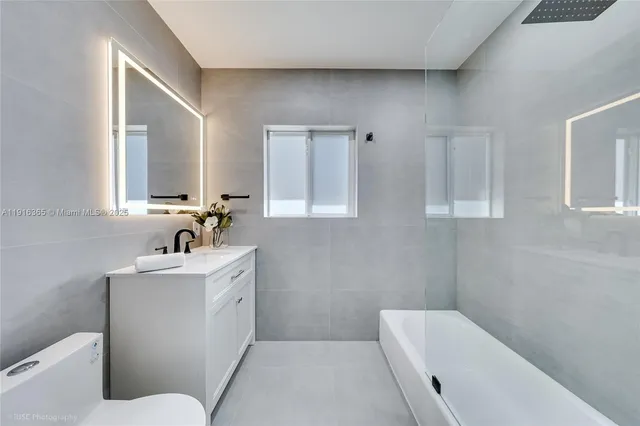 a bathroom with a sink a toilet and mirror