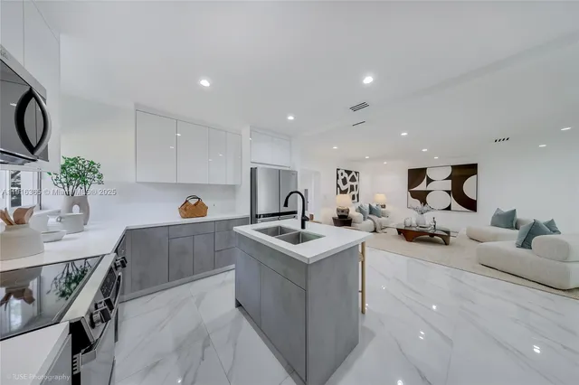 a kitchen with white cabinets and sink