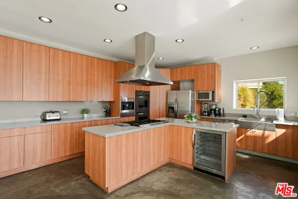 a large kitchen with stainless steel appliances a sink and cabinets
