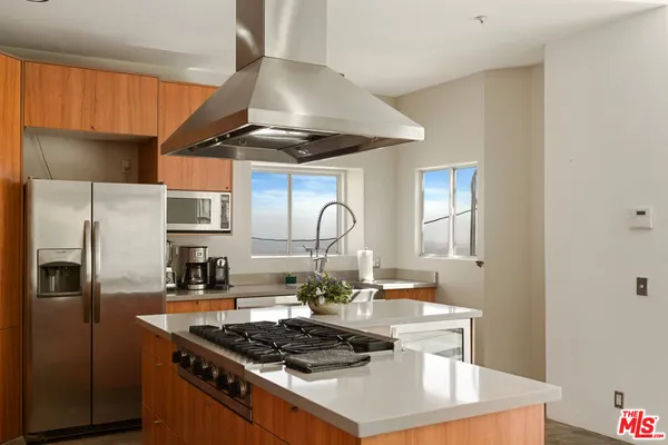 a kitchen with stainless steel appliances a stove a sink and a refrigerator