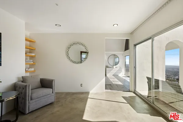 a living room with furniture and a painting on the wall