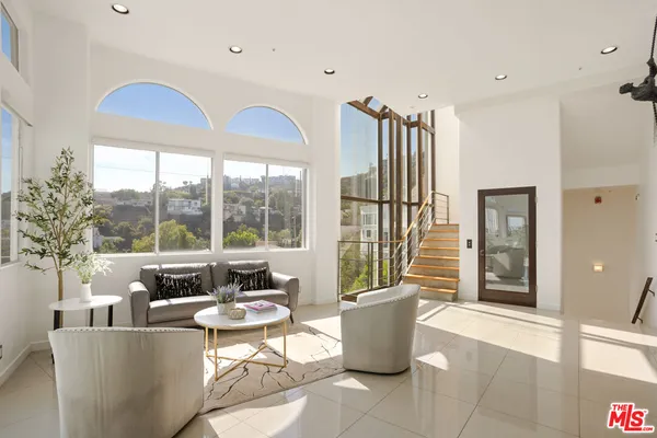 a living room with furniture and large windows