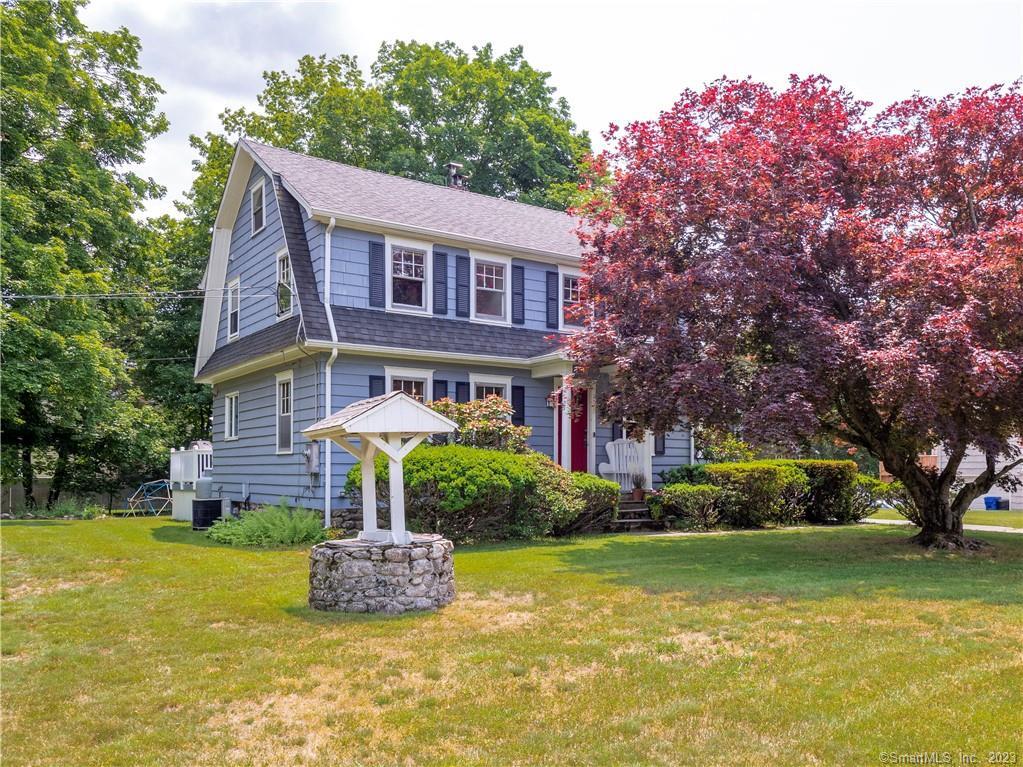 a front view of a house with a yard garage and tree