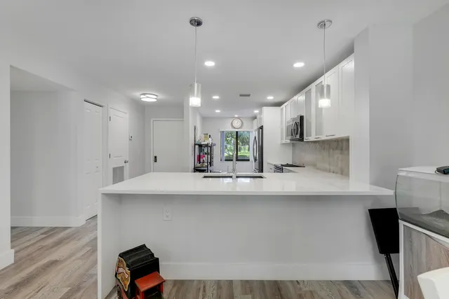 a kitchen with kitchen island a sink and a stove with wooden floor