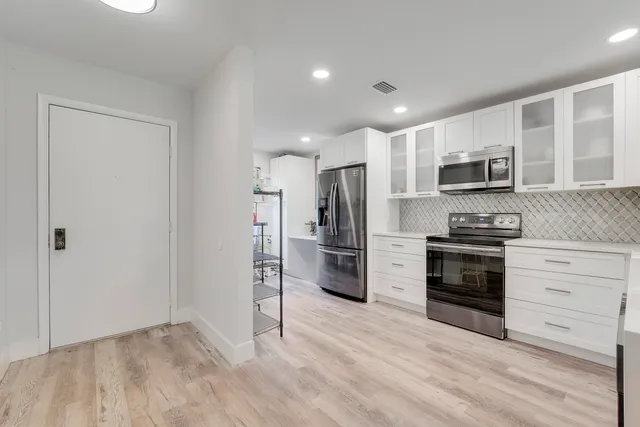 a kitchen with stainless steel appliances a refrigerator stove and microwave