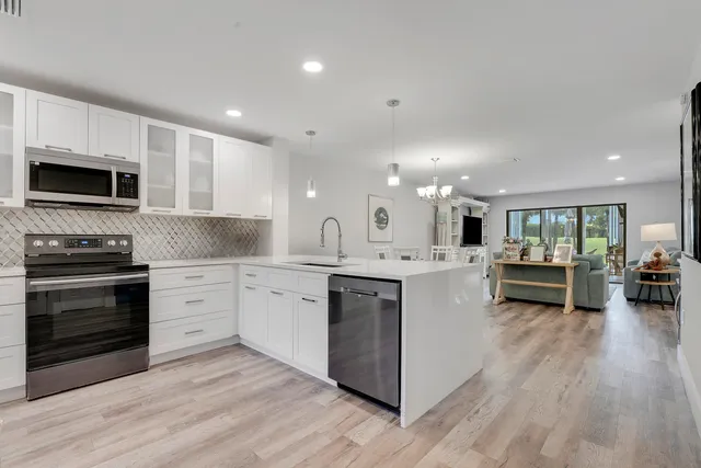 a kitchen with stainless steel appliances a stove a sink and a microwave
