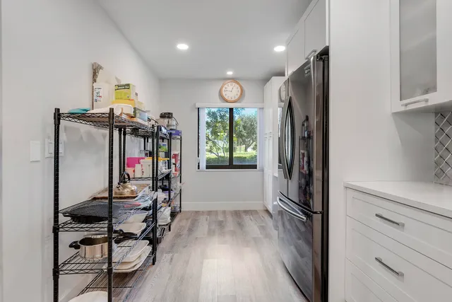 a view of a hallway with wooden floor and windows