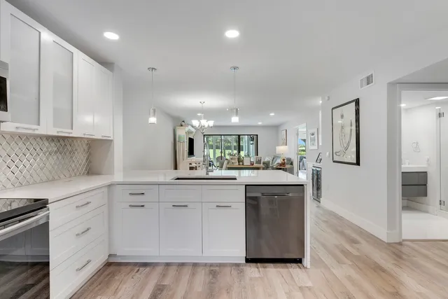 a kitchen with white cabinets appliances and sink