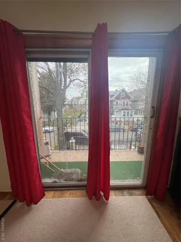a view of a room with a large window and bed in a room
