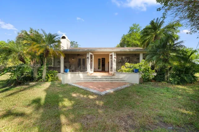 a front view of a house with a yard and potted plants