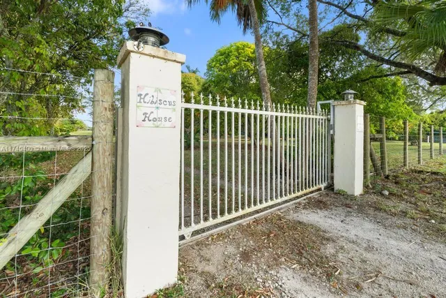 a view of a house with a yard and large trees