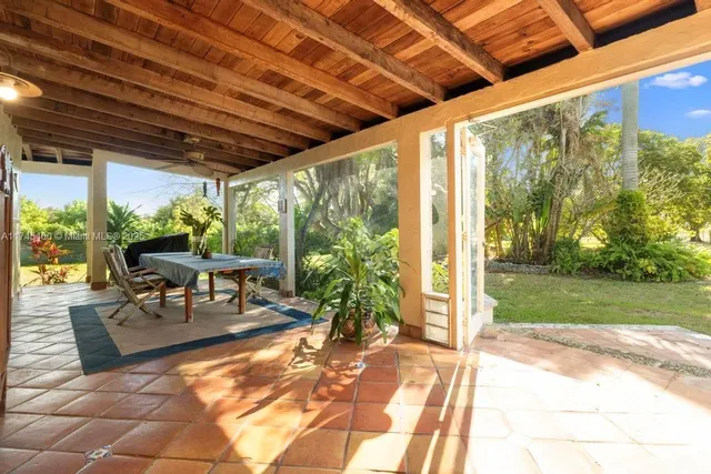 a view of a porch with chairs and backyard