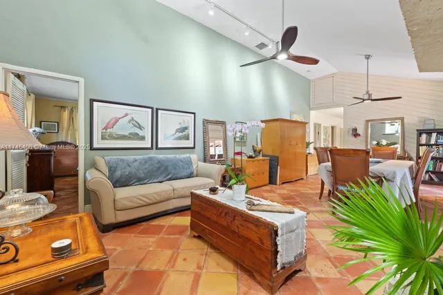 a living room with furniture kitchen view and a large window