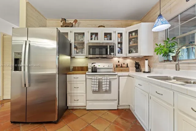 a kitchen with stainless steel appliances granite countertop a refrigerator and a sink