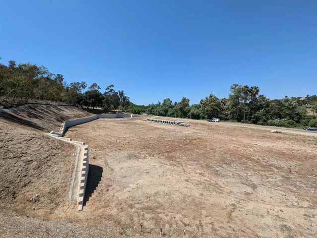 a view of a dry yard with wooden fence