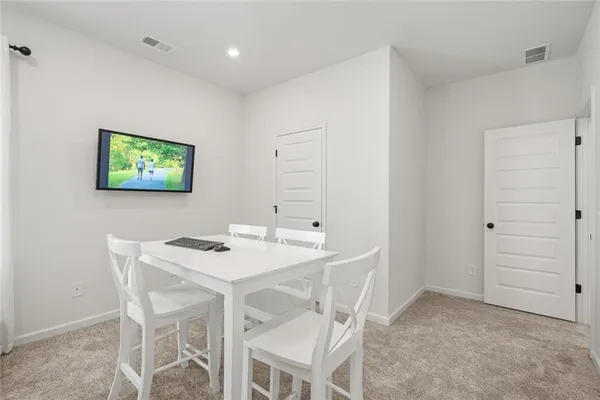 a patio with table and chairs and potted plants