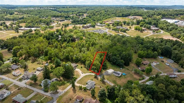 an aerial view of residential houses with outdoor space and trees