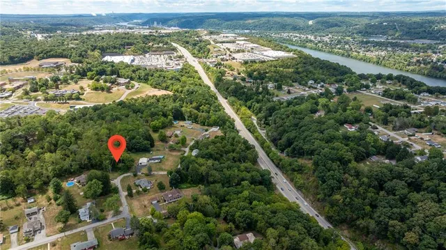 an aerial view of residential houses with outdoor space and trees