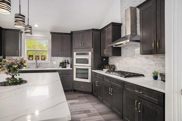 a kitchen with stainless steel appliances granite countertop a sink stove and refrigerator