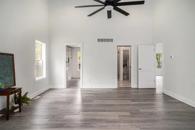 an empty room with wooden floor and windows