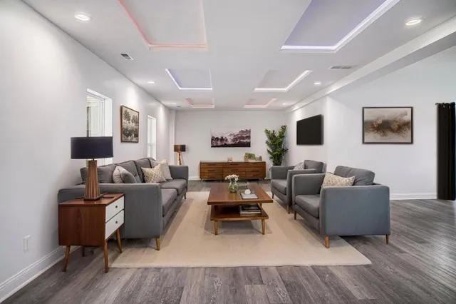 a living room with furniture and a wooden floor