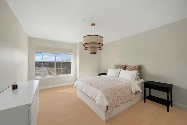 a bedroom with a bed and a chandelier