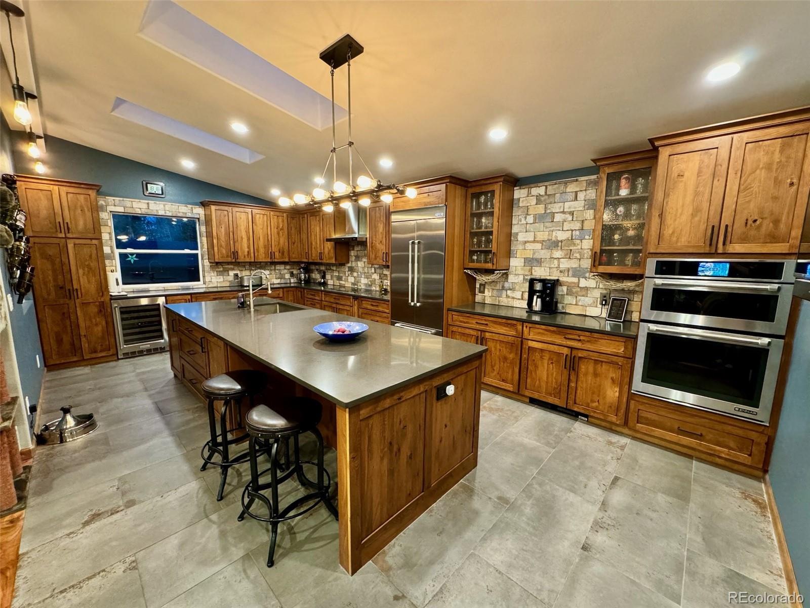 20670 Rangeview Drive Morrison, CO 80465 - Photo 13 of 39 a kitchen with stainless steel appliances a sink a stove a refrigerator and chairs