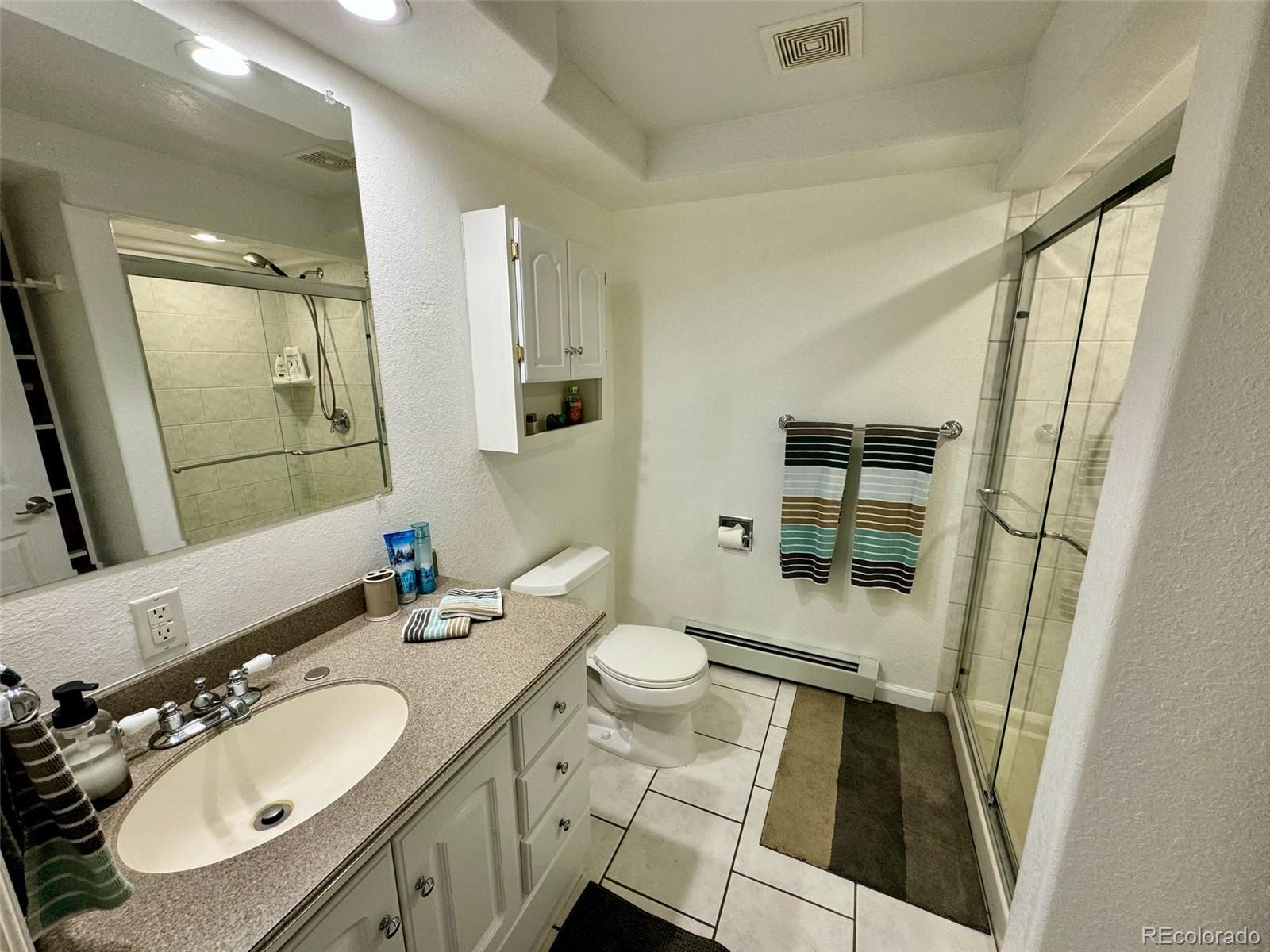 20670 Rangeview Drive Morrison, CO 80465 - Photo 29 of 39 a bathroom with a sink a toilet a mirror and shower