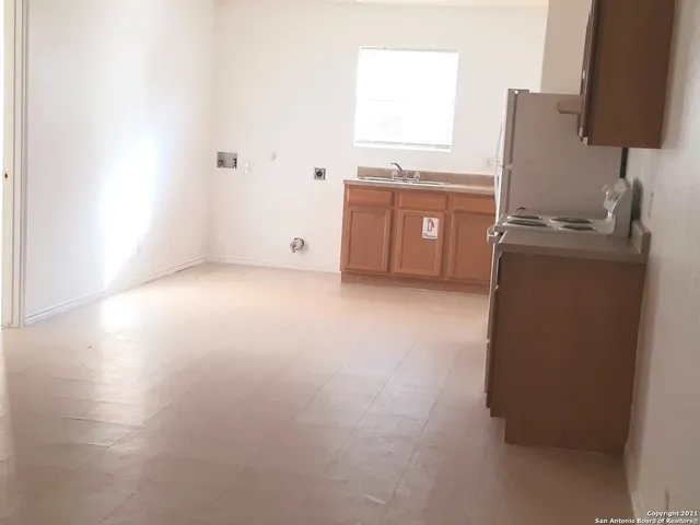 a kitchen with granite countertop a sink stove and refrigerator
