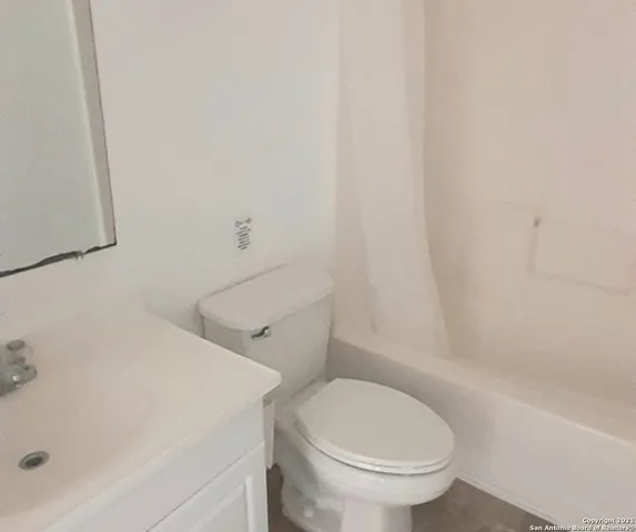 a white toilet sitting next to a bath tub