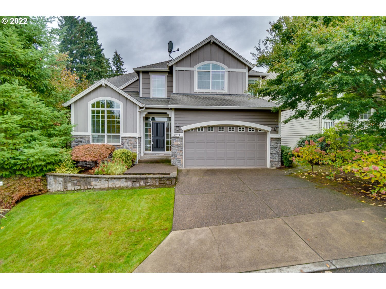 17496 Southwest 105th Avenue Tualatin, OR 97062 - Photo 1 of 28 a front view of a house with a yard and garage