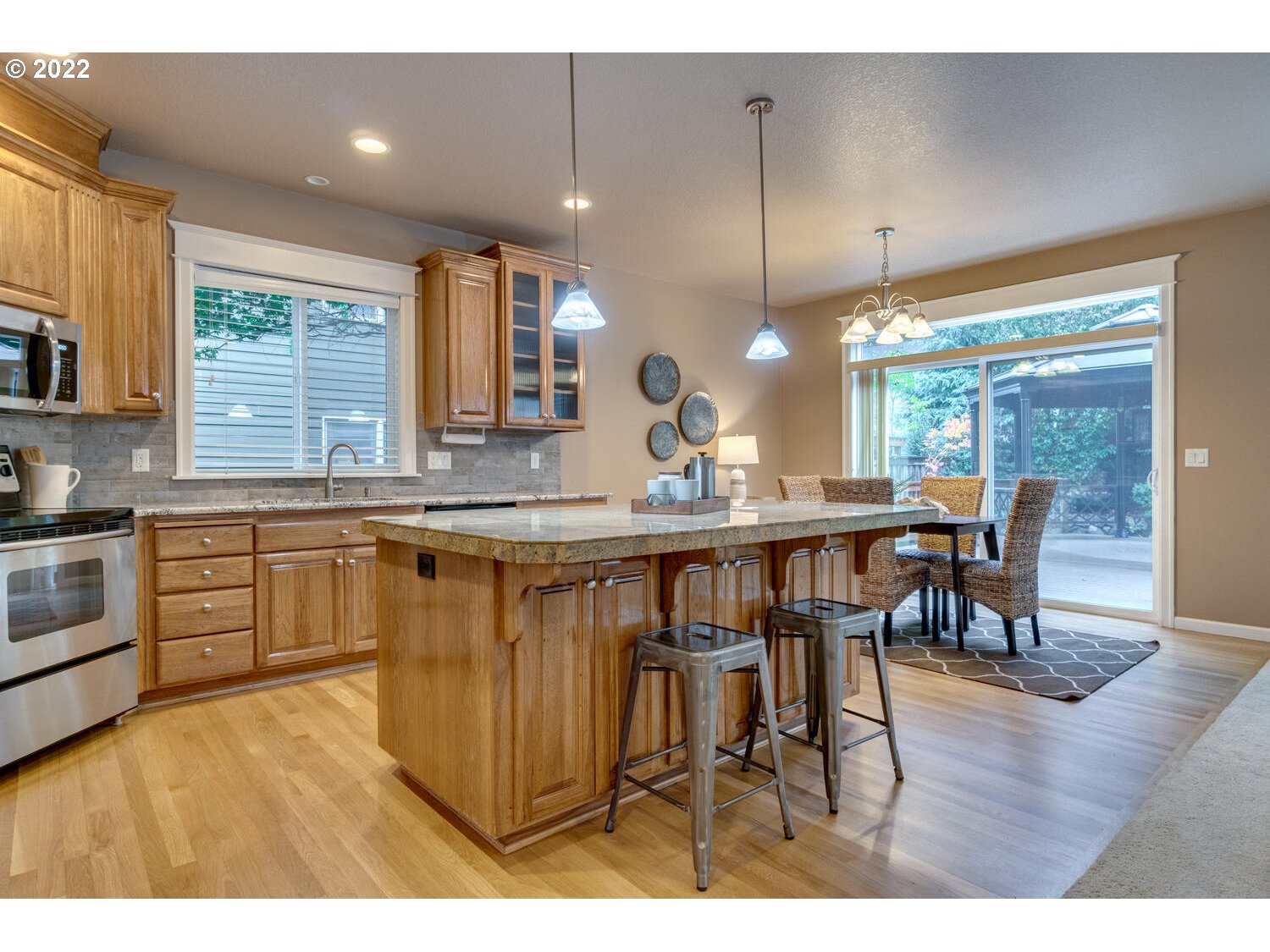 17496 Southwest 105th Avenue Tualatin, OR 97062 - Photo 11 of 28 a kitchen with stainless steel appliances granite countertop wooden floors and white cabinets
