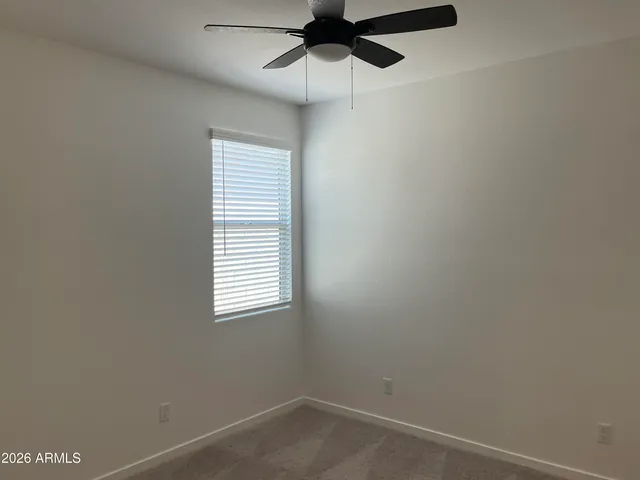 an empty room with a window and a fan