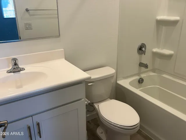 a white toilet sitting next to a bath tub