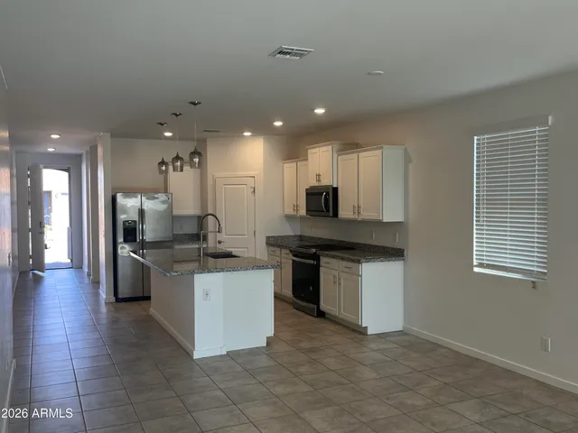 a large kitchen with stainless steel appliances kitchen island granite countertop a large counter top and stove
