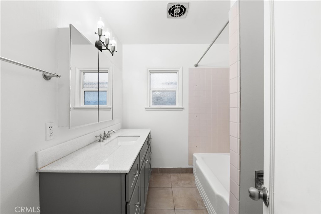 587 East Arrow Highway Upland, CA 91786 - Photo 11 of 17 a bathroom with a sink a mirror and a shower