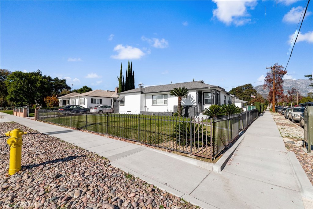 587 East Arrow Highway Upland, CA 91786 - Photo 2 of 17 a front view of a house with a yard
