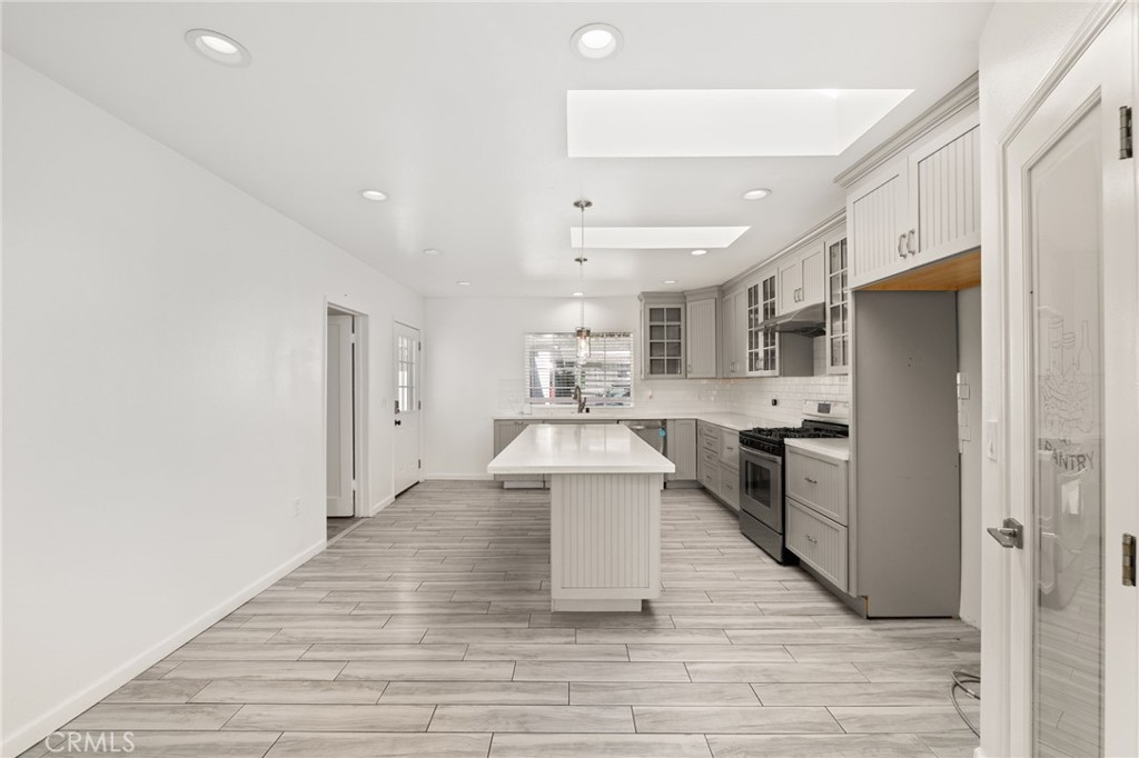 587 East Arrow Highway Upland, CA 91786 - Photo 6 of 17 a large white kitchen with stainless steel appliances