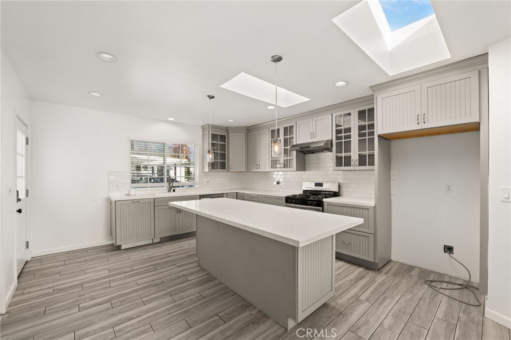 587 East Arrow Highway Upland, CA 91786 - Photo 7 of 17 a kitchen with a sink stove and cabinets