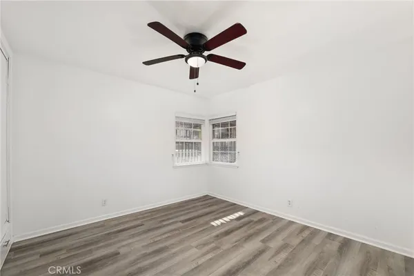 an empty room with a ceiling fan and window